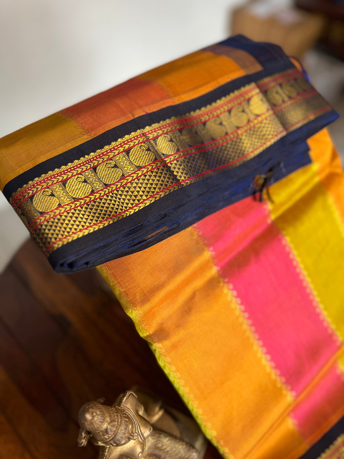 Korvai  Multi coloured silk cotton- Orangish Pink, Sampangi Yellow, Turmeric Yellow with Navy blue border